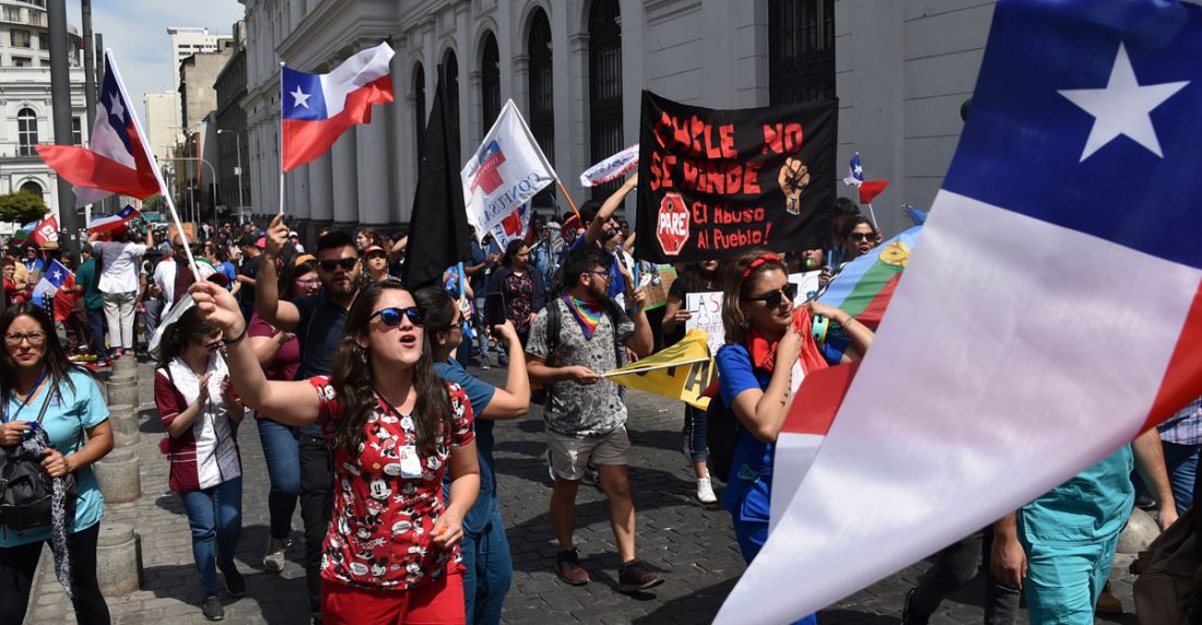 Los trabajadores de salud protestan con banderas nacionales chilenas en Santiago en la cuarta semana de protestas contra el gobierno de Piñera