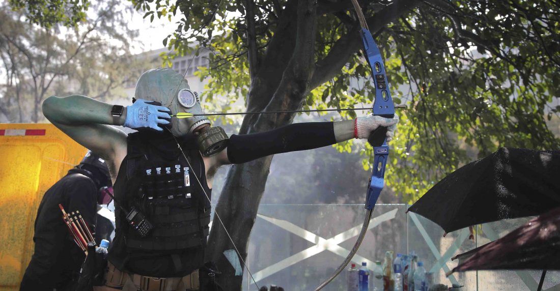 Un manifestante de Hong Kong dispara una flecha contra las fuerzas de seguridad